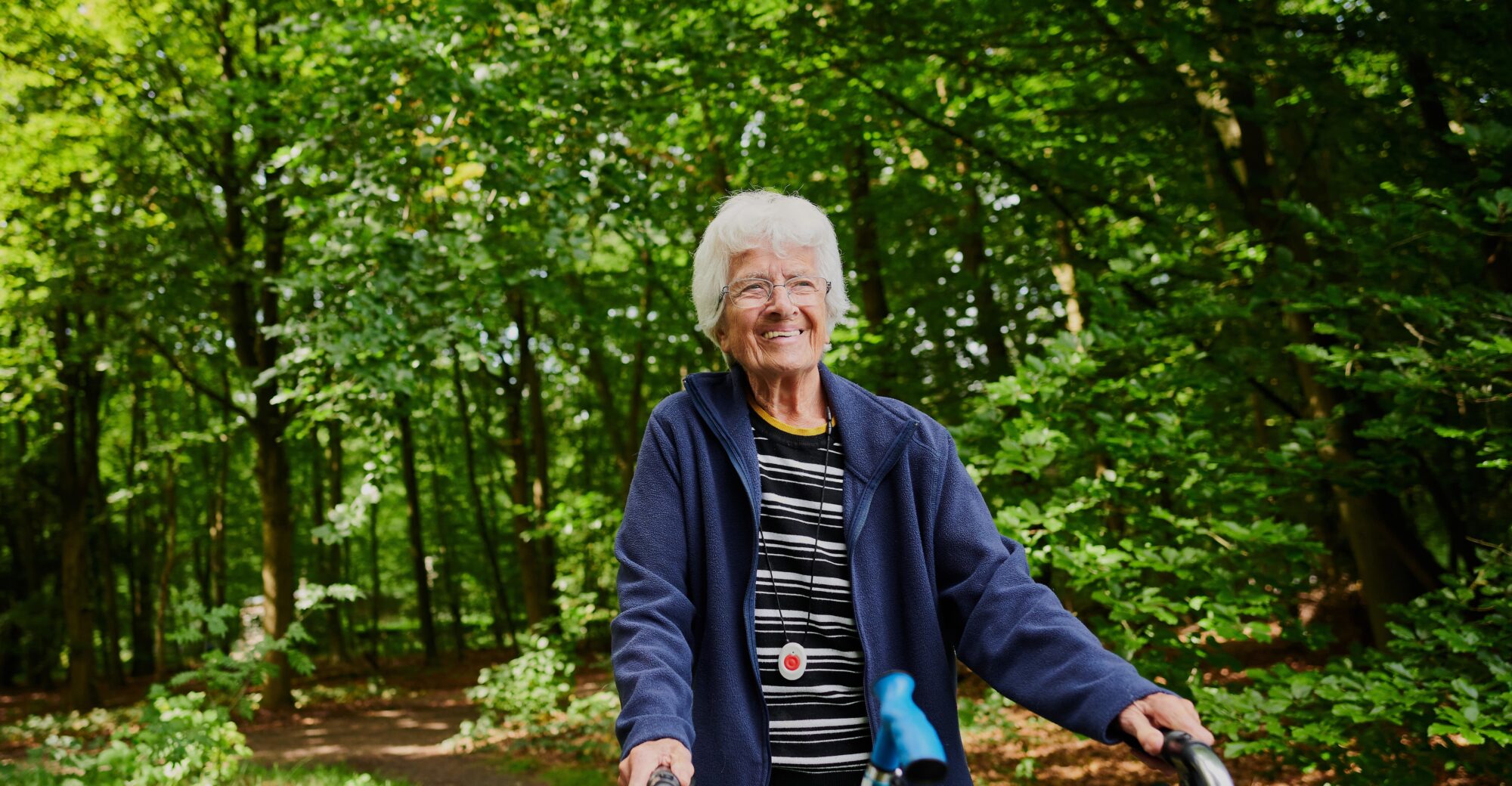 Oude vrouw achter een rollator die lacht